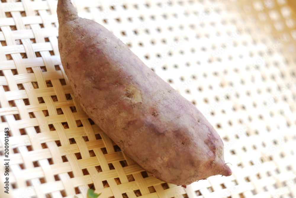 Raw sweet potato isolated on bamboo mat.