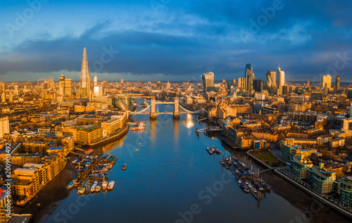 London  England - Panoramic aerial skyline view of London including iconic Tower Bridge with red double-decker bus  skyscrapers of Bank District at golden hour early in the morning with blue sky