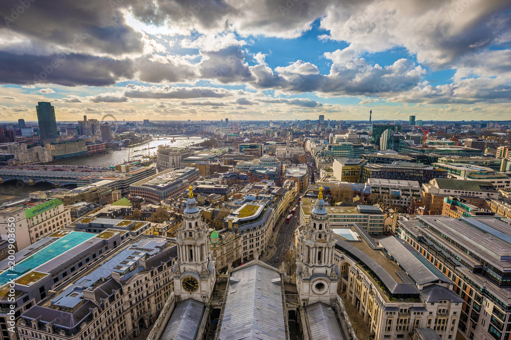 London, England - Panoramic skyline view of London taken from St. Paul's Cathedral with iconic red double-decker buses and beautiful sky and clouds