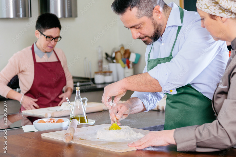 Chef teaching how to make fresh egg pasta at Italian cooking class Chef teaching how to make fresh egg pasta at Italian cooking class