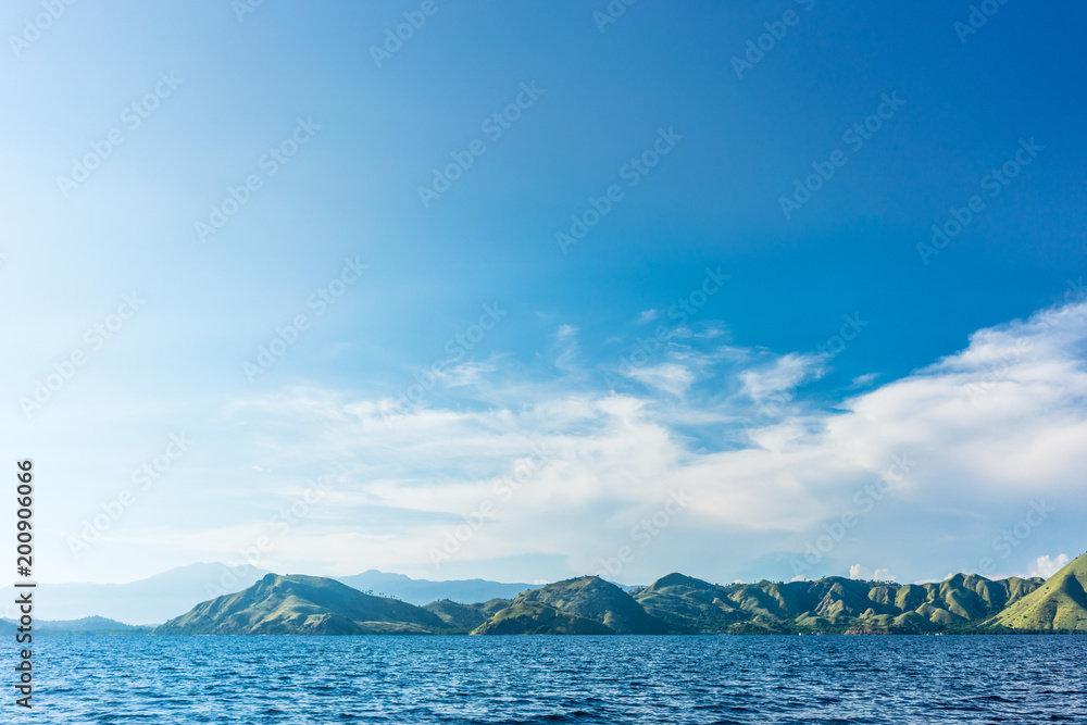Idyllic seascape with the coastline of Flores Island against a cloudy sky, famous travel destination from Indonesia