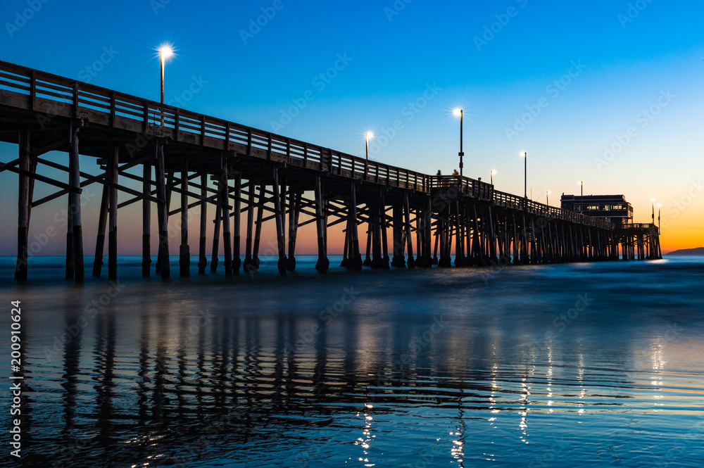 Naklejka premium California Złoty zachód słońca na molo plaży w Newport