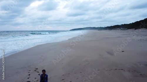 Exotic aerial scenery of Pangumbahan beach with a person walking on the white sand at Ujung Genteng, Sukabumi, West Java, Indonesia photo