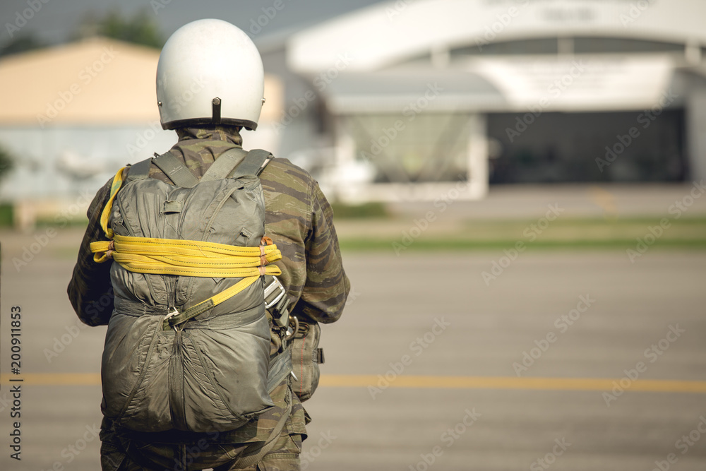tactical paratrooper in camouflage uniform with T-10 parachute standby at airfield