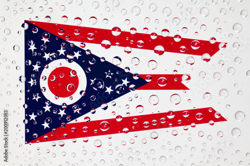 Flag of American State Ohio behind a glass covered with rain drops. photo