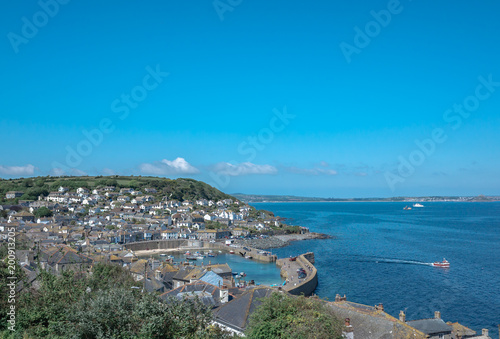 Fishing boat leaving Mousehole harbour on a beautiful summer day Cornwall England photo