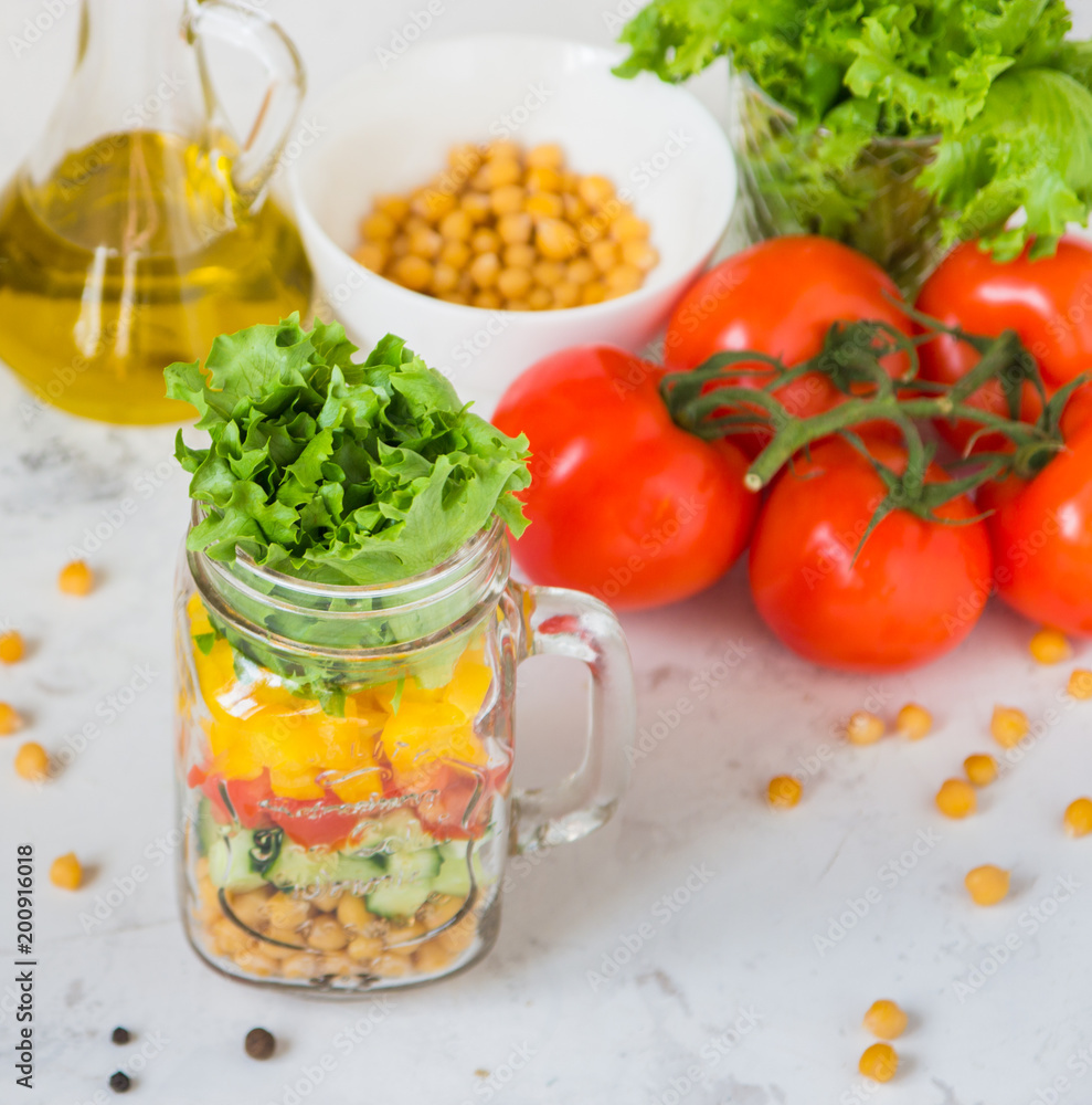 Salad in a jar. Homemade healthy salad from chickpea, tomato, yellow paprika, cucumber and green lettuce Salad in a jar. Homemade healthy salad from chickpea, tomato, yellow paprika, cucumber and green lettuce