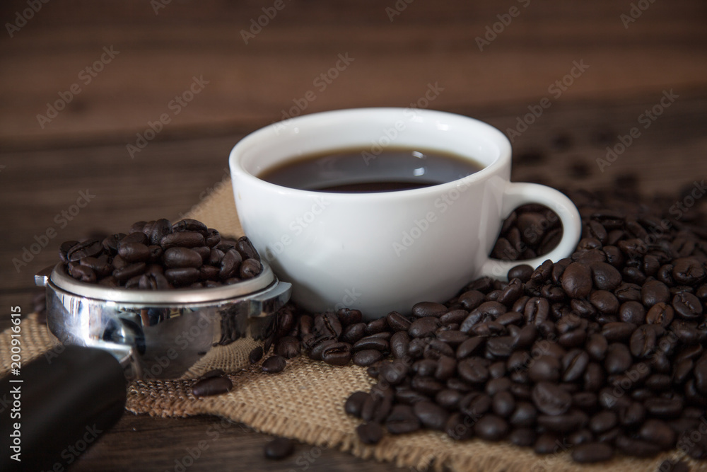 Hot coffee and coffee beans on wooden table. Hot coffee and coffee beans on wooden table.