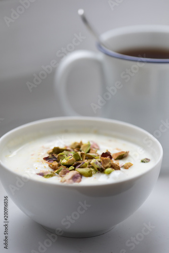 Joghurt mit Pistazien zum Frühstück mit Becher Ceylon Assam Tee