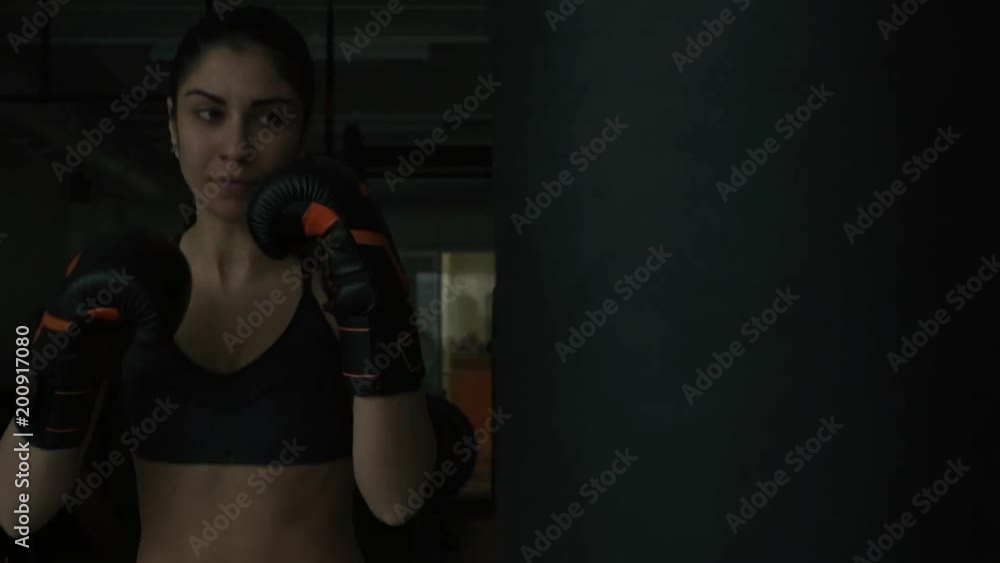 Boxer woman hitting the punching bag at the gym Boxer woman hitting the punching bag at the gym