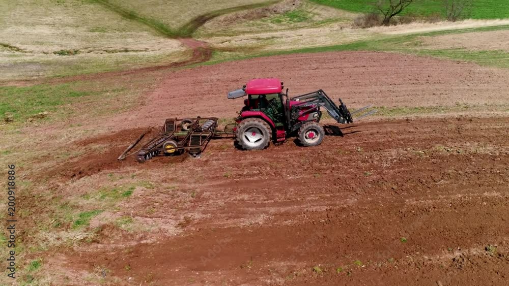 Aerial view or tractor plowing fresh earth as camera moves over and past the tractor. Aerial view or tractor plowing fresh earth as camera moves over and past the tractor.