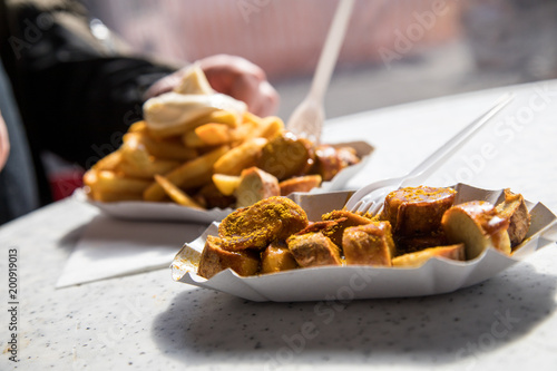 Wallpaper Mural Mann isst Currywurst Pommes Mayo draußen am Wochenmarkt Imbiss Torontodigital.ca