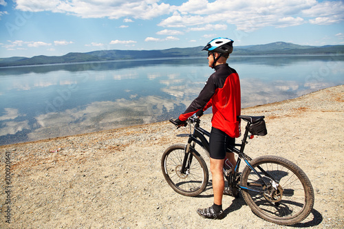 cyclist on the shore of a mountain lake