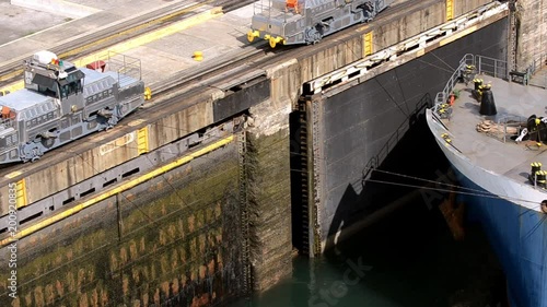 Trains pulling a oil tanker ship through the locks in Gatun Panama.