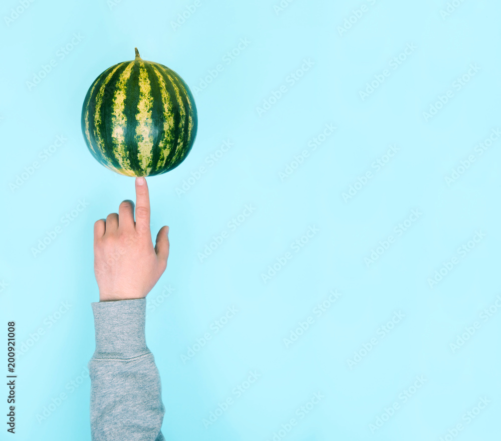 Male hand balancing a watermelon on a finger. Male hand balancing a watermelon on a finger.