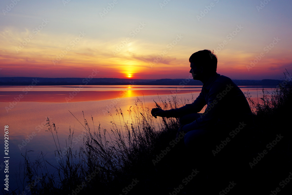 A young man looks at the sunset