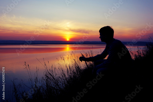 A young man looks at the sunset