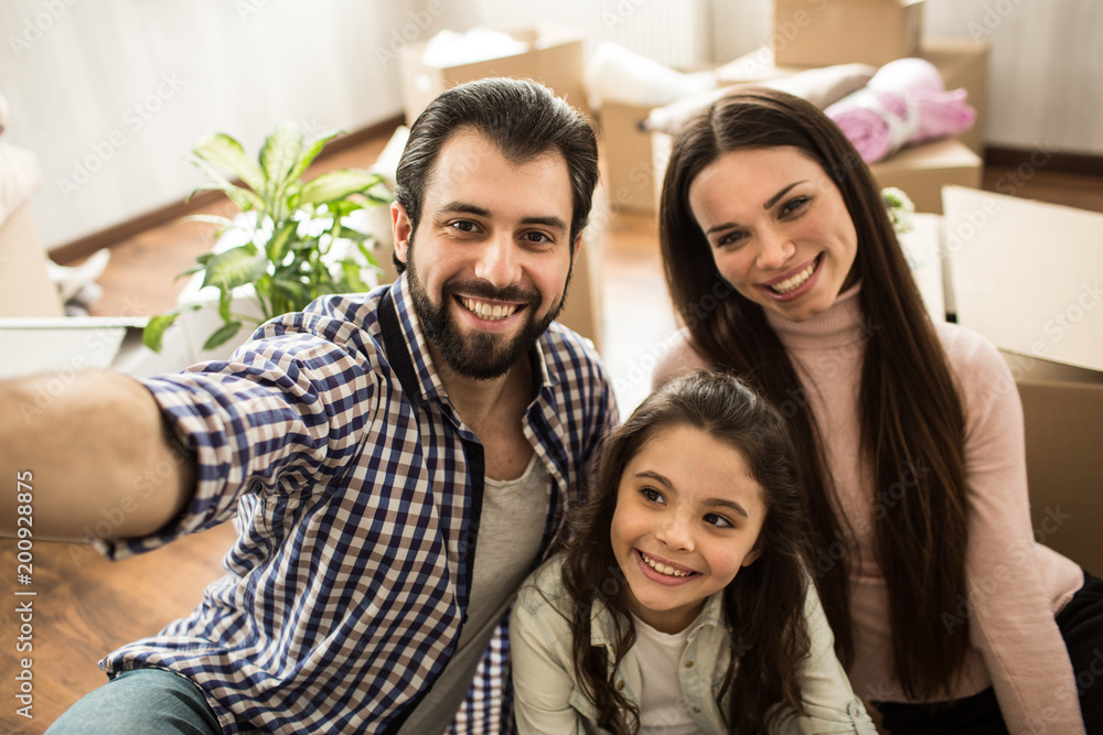 Fototapeta premium Selfie of happy family. They are looking on the camera and smiling. This family is very beautiful.