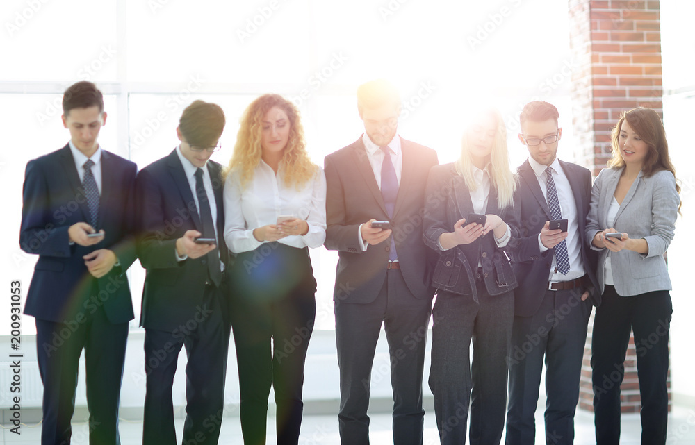 Obraz premium business team looking to smartphone in office