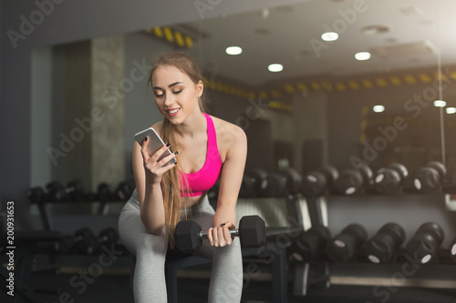 Young girl using mobile phone at gym