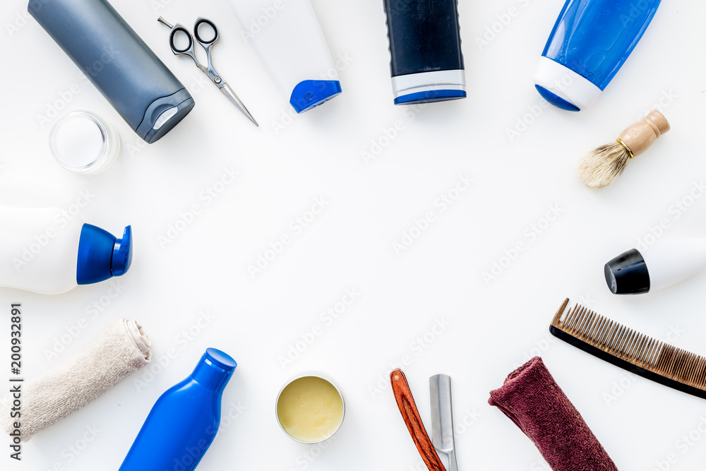 Cosmetics for men's hair. Bottles with shampoo and gel, tools for brushing, sciccors on white background top view copy space Cosmetics for men's hair. Bottles with shampoo and gel, tools for brushing, sciccors on white background top view copy space
