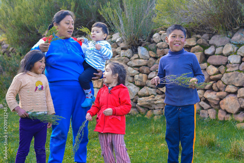 Happy native american family showing typical peruvian plant called tipollo. photo