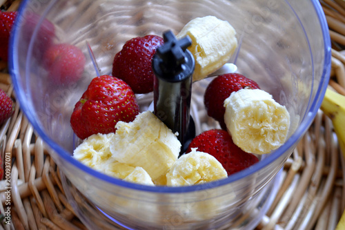 Ingredients for smoothies in blender. Bananas and strawberries