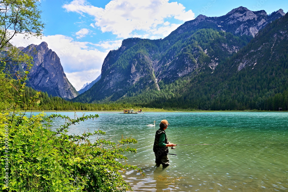 Italian Dolomites - fisherman in the lake Toblachersee Italian Dolomites - fisherman in the lake Toblachersee