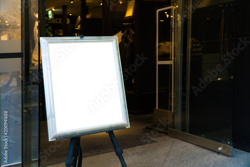 empty wood frame poster display on glass window at shop storefront,sale and discount promotion information for announcement successful business marketing,selective focus