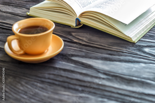 open book cup with coffee on a wooden background with copy space, top view