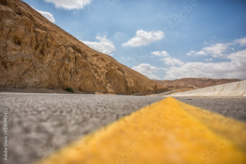 Road  and yellow crossline in the arid southern mountains photo