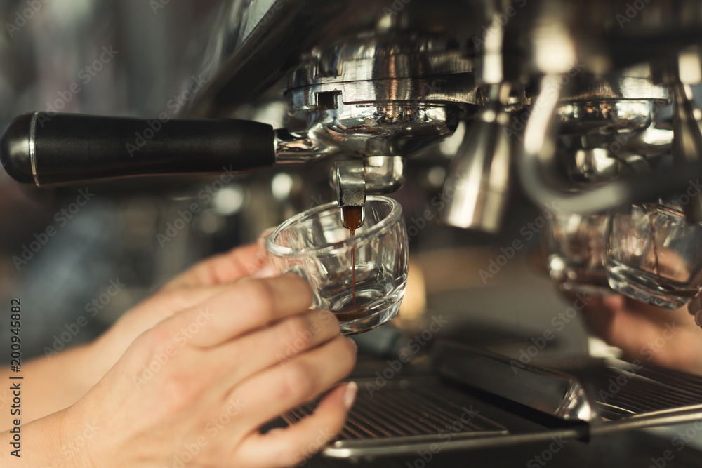 Closeup of barmen hand brewing espresso in professional coffee machine