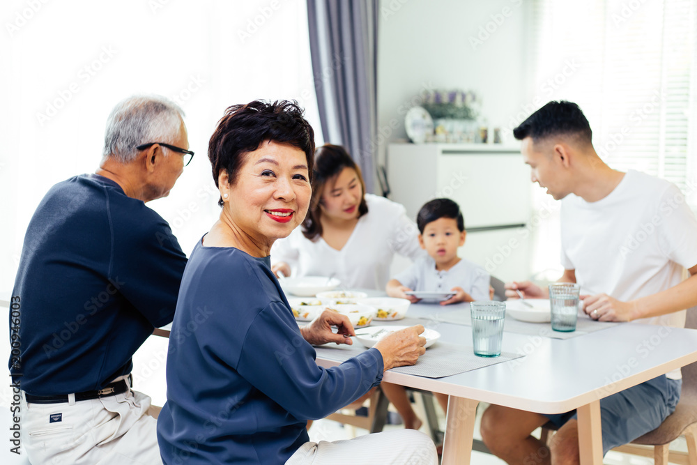 Happy Asian extended family having dinner at home full of happiness and smiles Happy Asian extended family having dinner at home full of happiness and smiles