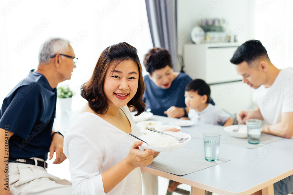Happy Asian extended family having dinner at home full of happiness and smiles Happy Asian extended family having dinner at home full of happiness and smiles