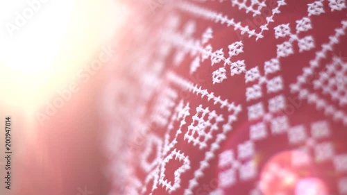 Red texture cloth embroidered with thick white thread in warm sunlight, close-up. Vyshyvanka, traditional folk ethnic ukrainian national costume. Eastern European hand embroidered shirt sorochka.