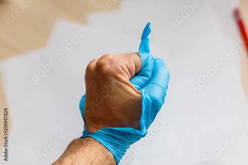 Hand wearing torn plastic protective glove photo