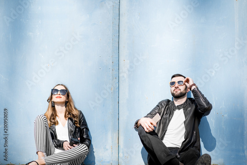 Couple sitting on the blue wall background