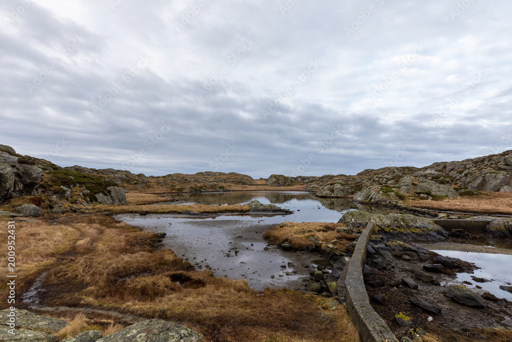 Brown winter landscape with beautiful sky. Pond by the trail, at the Rovaer archipelago, island in Haugesund, Norway.