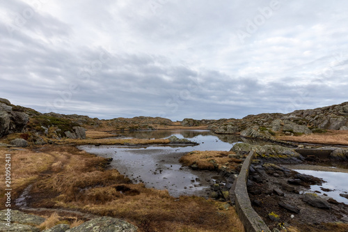 Brown winter landscape with beautiful sky. Pond by the trail, at the Rovaer archipelago, island in Haugesund, Norway.