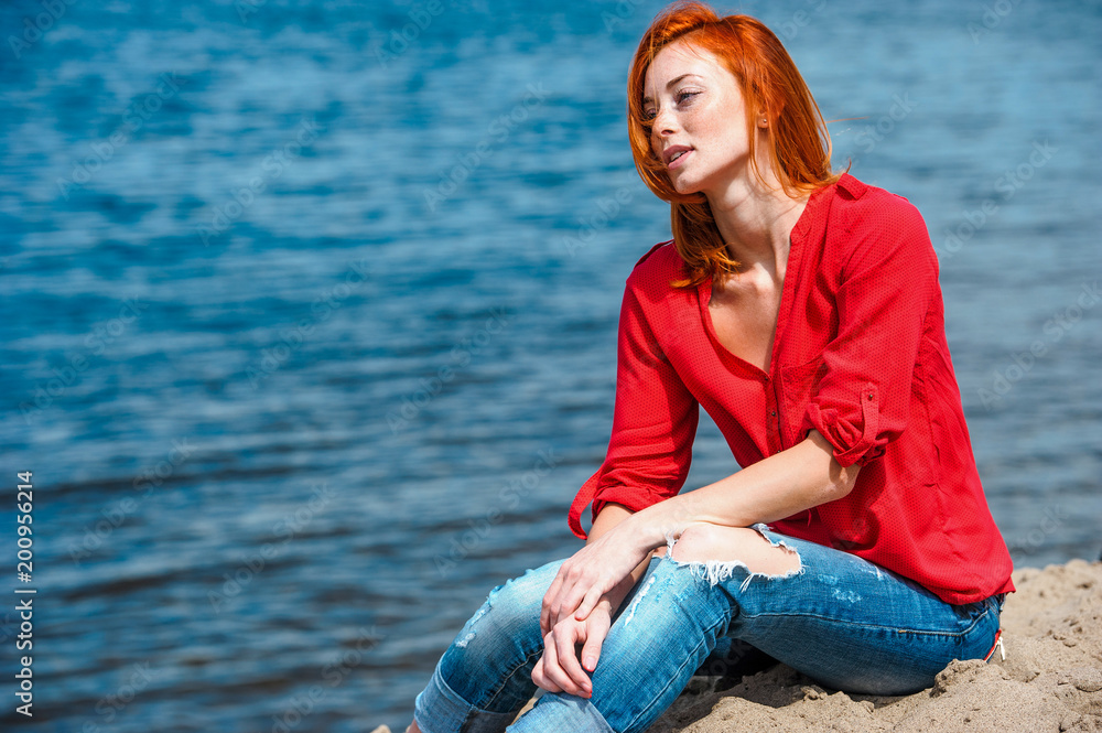 Joyful redhead woman senjoying a sunny day at the beach