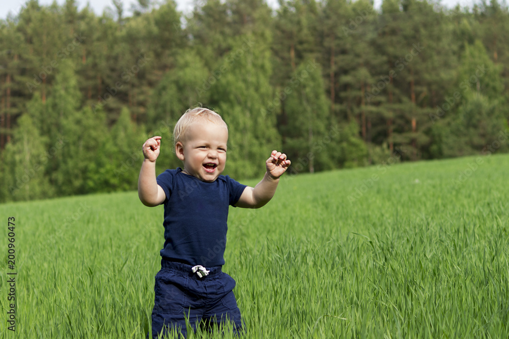 Happiness Baby boy sitting on the grass in field Happiness Baby boy sitting on the grass in field