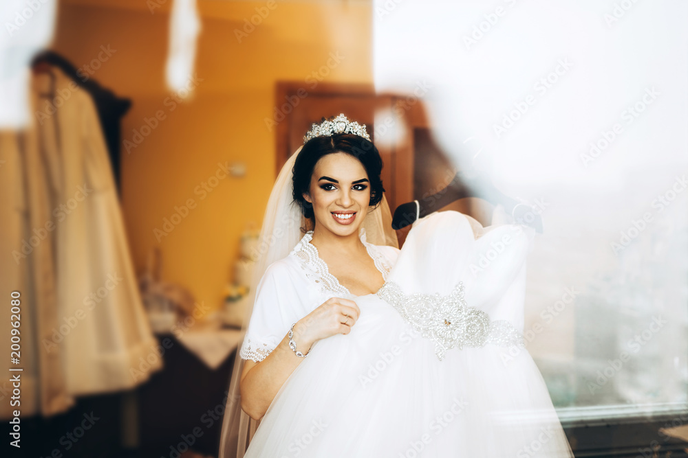 Naklejka premium Pretty bride dressing up before wedding ceremony