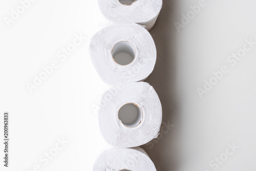 Directly above view of white recycled toilet paper rolls in a column on white background