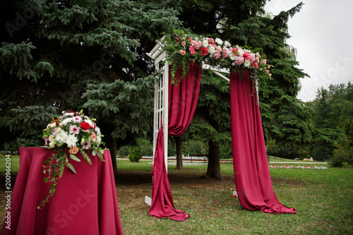 Wedding arch for wedding ceremony. Beautiful marsala wedding decor and decoration with fresh flowers