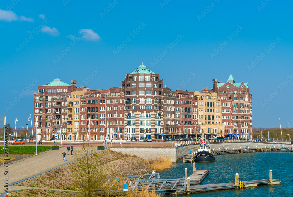 Fototapeta premium Lelystad, The Netherlands april 11 2018, tourist walking towards the buildings of the Lelystad Harbour