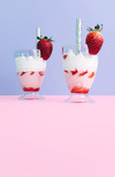 Milkshake with straw and strawberry.