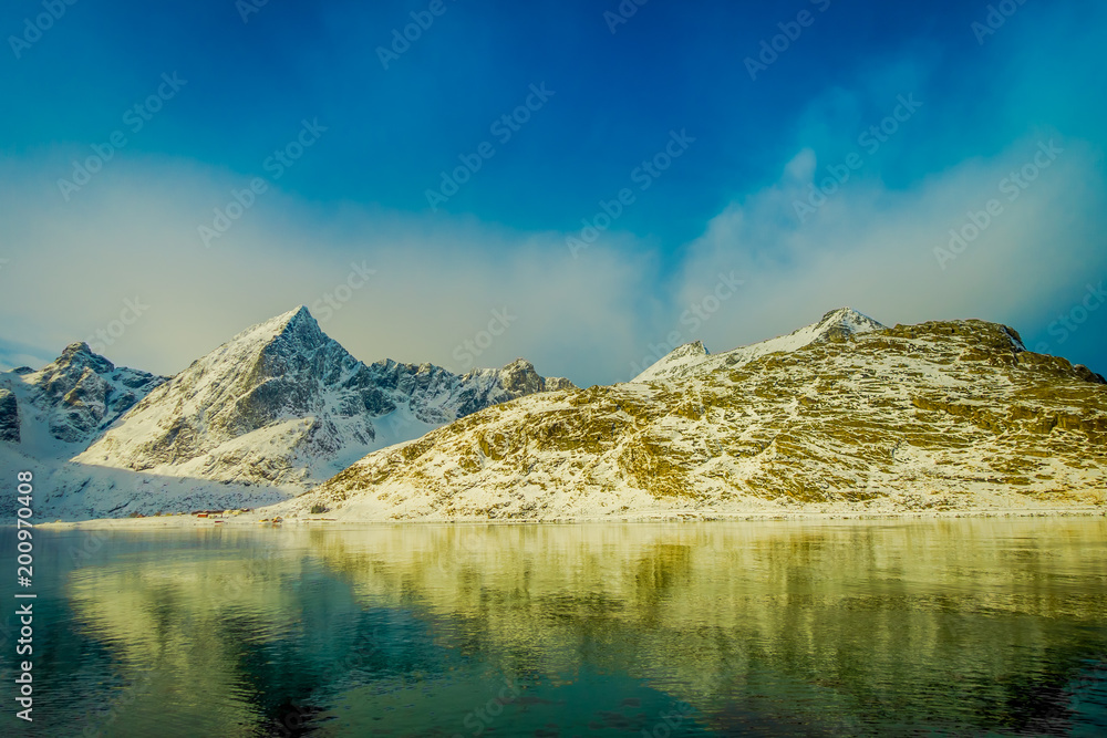 Gorgeous view of mountain peaks and reflection in water on Lofoten islands