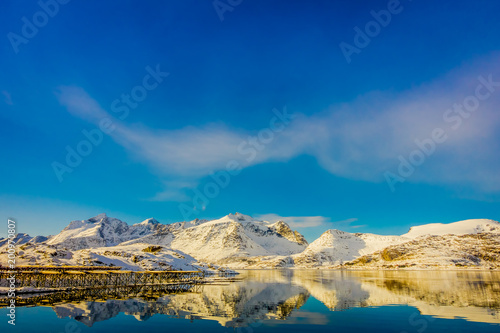 View of mountain reflecting in the water with cod stock fish heads located at one side of the lake on Lofoten islands