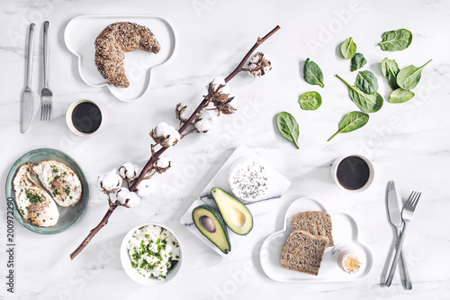 Fototapeta Naklejka Na Ścianę i Meble -  Variety of healthy breakfast with vegetables, cottage cheese, avocado, cup of coffee and seeds on the kitchen marble table.