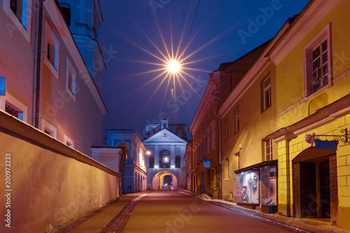 Picturesque Street and Gate of Dawn at night in Old Town of Vilnius, Lithuania, Baltic states. Used toning